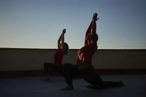 Women practice the Warrior Pose in Hatha Yoga, an ancient practice that fosters balance and harmony with the natural body, on the outdoor rooftop at Dzokden Kalapa Center.