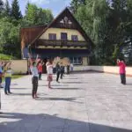 picture of Qigong class with a group of circa 10 people on the main terrace in front of the Kalachakra Temple in Austria